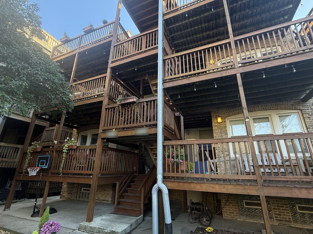 Wooden back porches with string lights and flower boxes on a brick building in Rogers Park